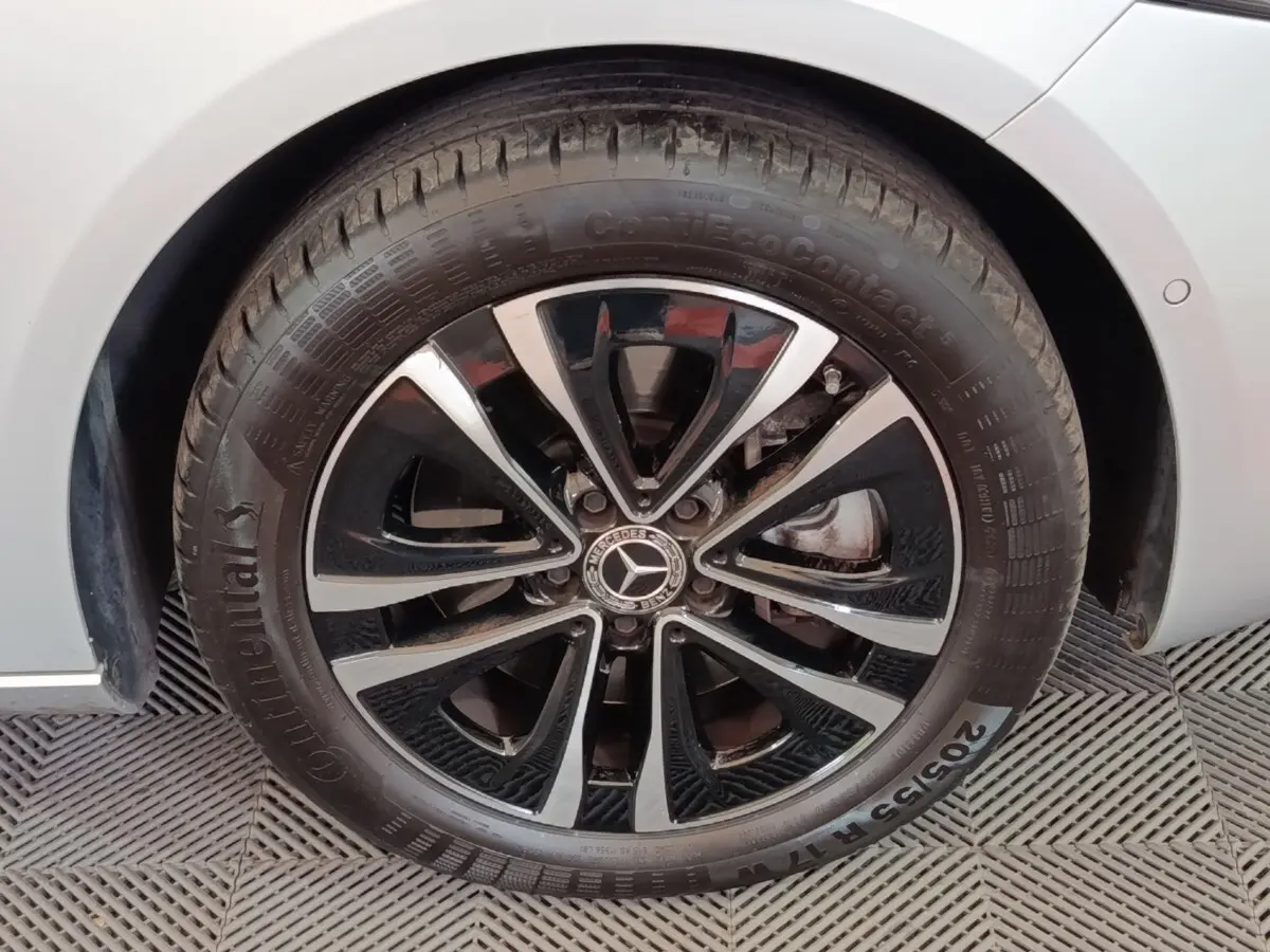 Gros plan sur la roue avant droite d’une Mercedes Classe A gris clair avec jante alliage noir et argentée.