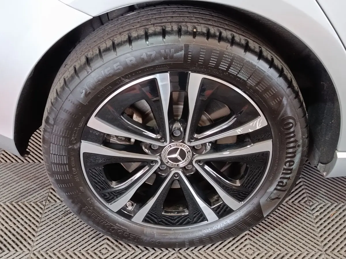 Gros plan sur la roue avant droite gris clair de la Mercedes Classe A 250 e Business Line avec jante alliage noir et argent.