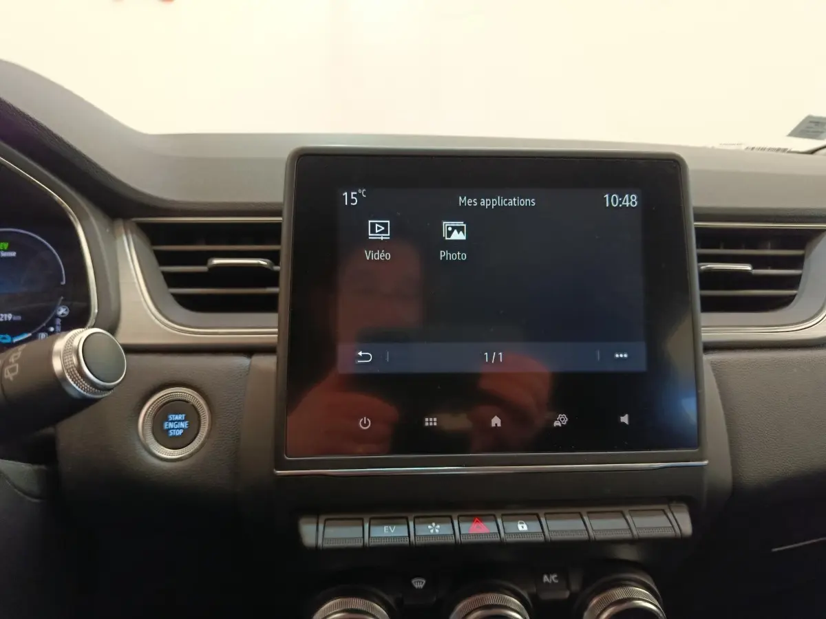 Vue intérieure centrée sur l'écran tactile et le tableau de bord du Renault Captur Intens E-TECH gris clair 2021.