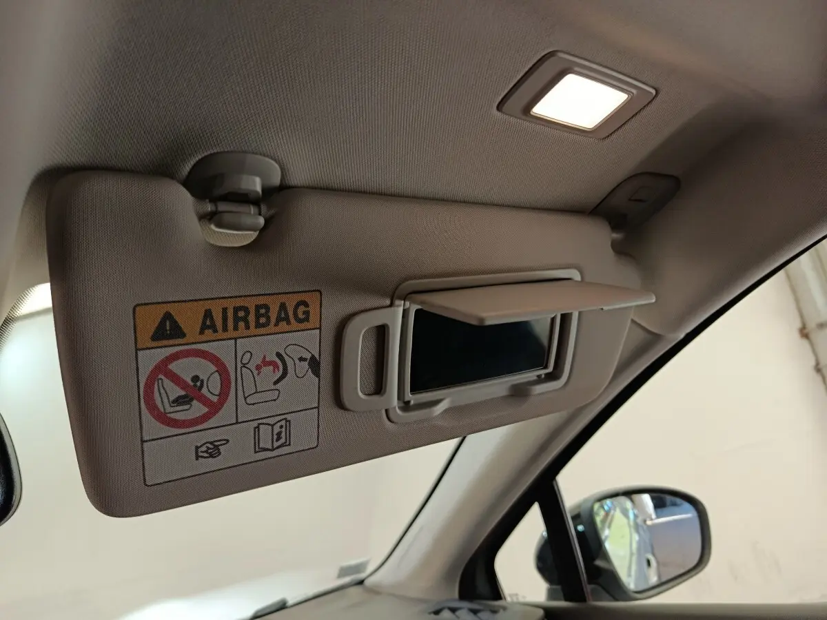 Détail intérieur du pare-soleil côté conducteur avec miroir et avertissement airbag dans un Renault Captur gris clair.