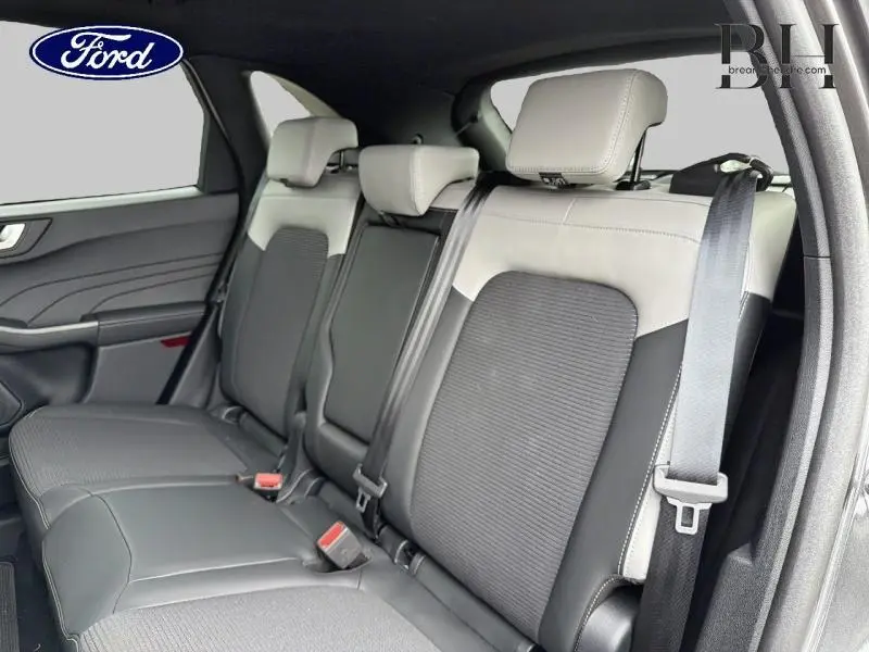 Vue intérieure côté droit de la banquette arrière bi-ton gris clair et foncé du Ford Kuga 2026 avec ceintures de sécurité visibles.