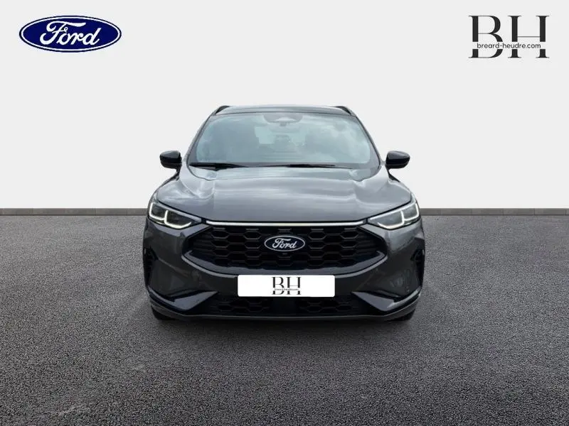 Vue avant du Ford Kuga 2.5 Hybrid gris Magnetic avec calandre noire et projecteurs Dynamic Matrix LED allumés.