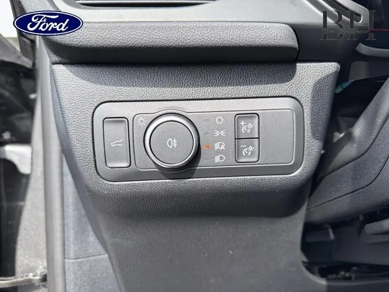 Gros plan sur les commandes d'éclairage côté gauche du tableau de bord du Ford Kuga gris Magnetic 2026.