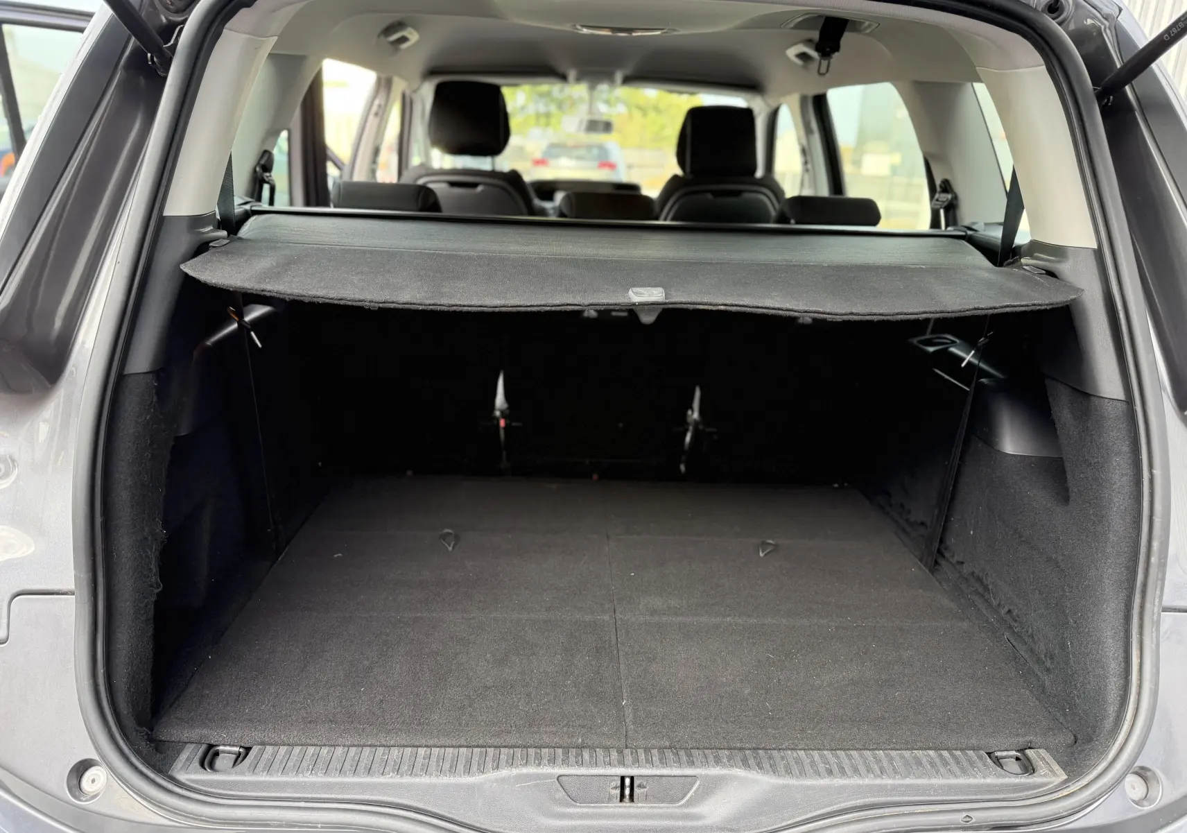 Coffre ouvert vu de l'arrière d'un Citroën Grand C4 Spacetourer gris 2019, avec cache-bagages déployé.