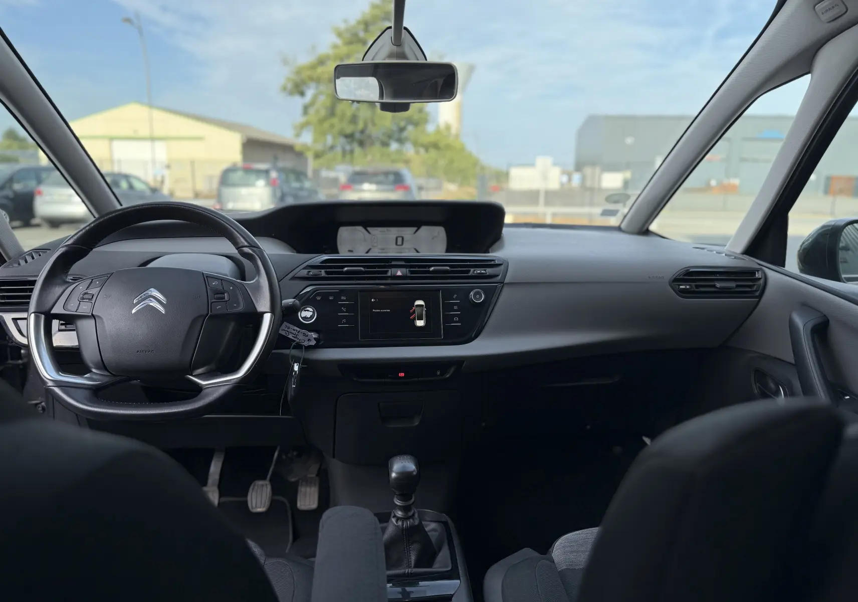 Vue intérieure avant du Citroën Grand C4 Spacetourer gris 2019, avec volant multifonction et tableau de bord digital.
