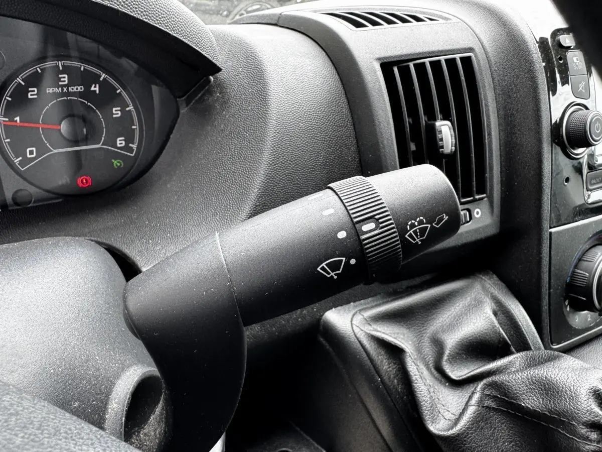Gros plan sur la commande d’essuie-glace côté gauche du tableau de bord noir du Citroën Jumper blanc de 2019.