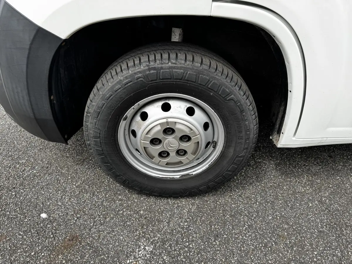 Gros plan sur la roue avant droite acier d’un Citroën Jumper blanc, avec logo Citroën au centre de la jante.
