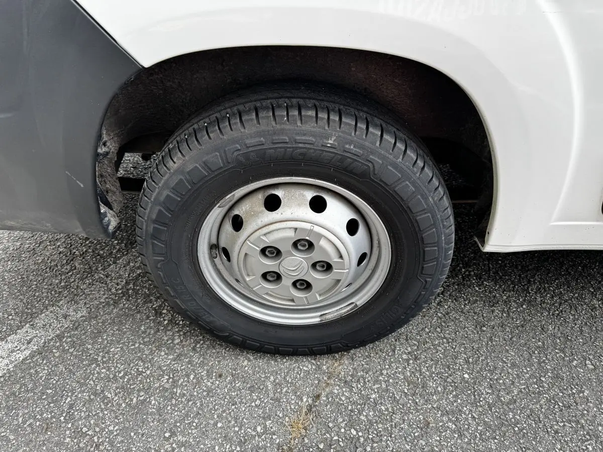 Gros plan sur la roue avant droite en jante acier du Citroën Jumper blanc, avec pneu Michelin visible.