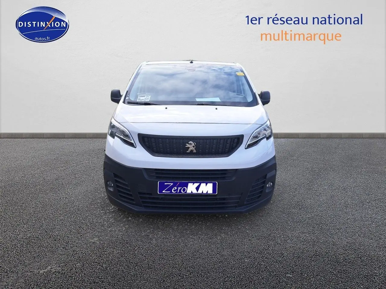 Vue frontale d'un Peugeot Expert Blanc Kaolin avec calandre noire et pare-chocs foncé sur sol gris.