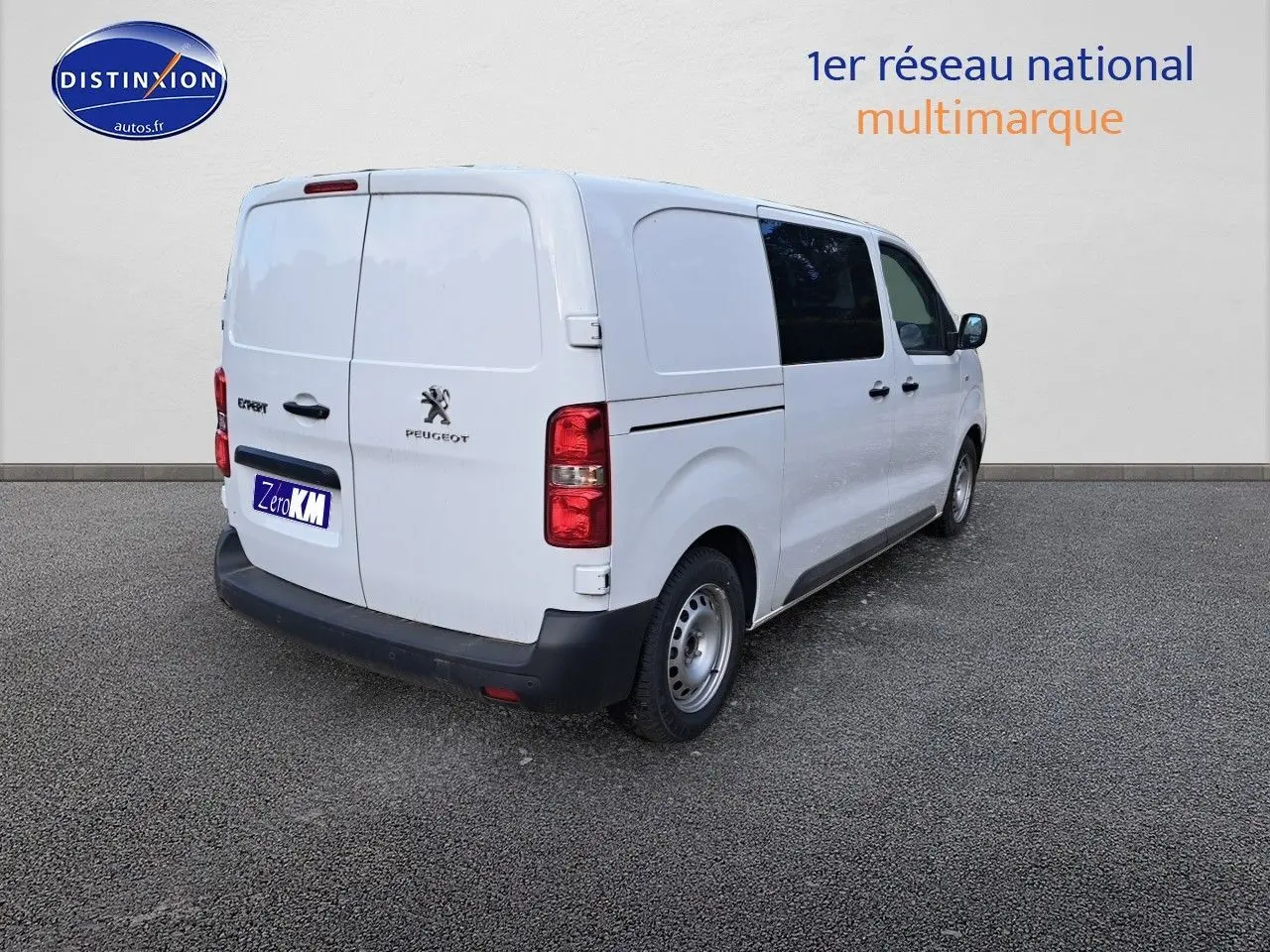 Vue 3/4 arrière droite d'un Peugeot Expert Blanc Kaolin, utilitaire avec vitres teintées et porte latérale coulissante.