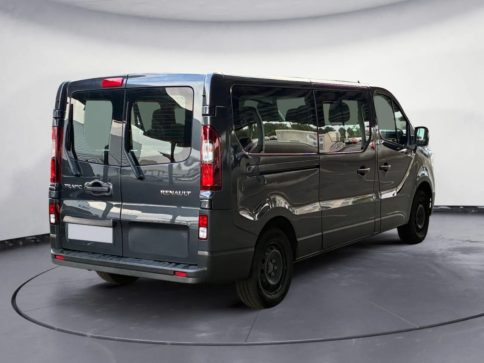 Vue 3/4 arrière droite d'un Renault Trafic Combi gris foncé métallisé, avec vitres latérales teintées et portes arrière battantes.
