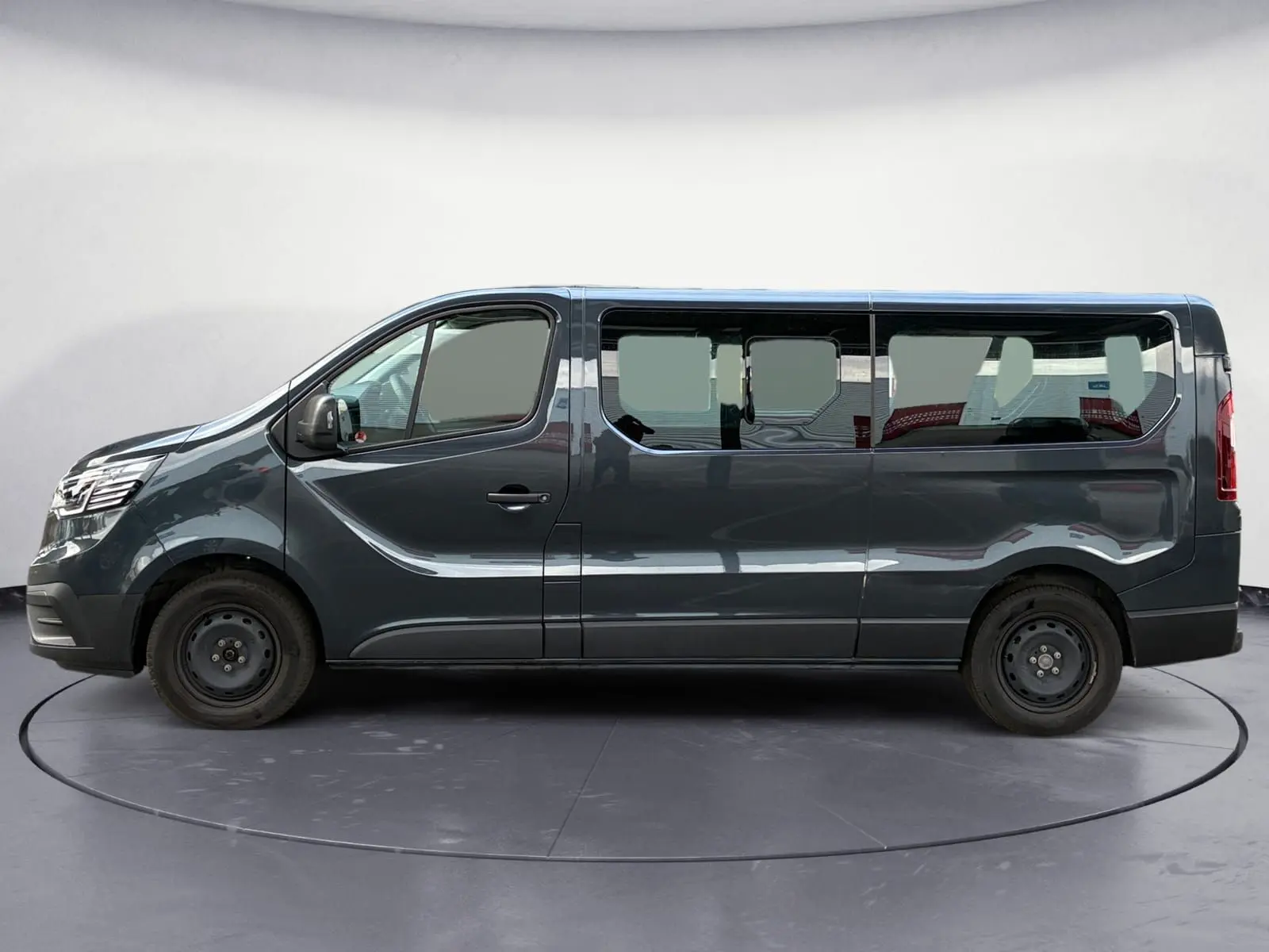 Profil côté gauche du Renault Trafic Combi gris foncé métallisé 2023 avec ses grandes fenêtres latérales.