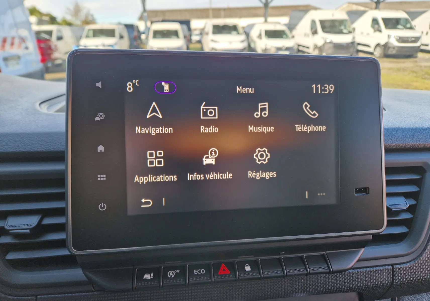 Écran tactile central du Renault Trafic Fourgon blanc, affichant le menu principal avec navigation et radio.