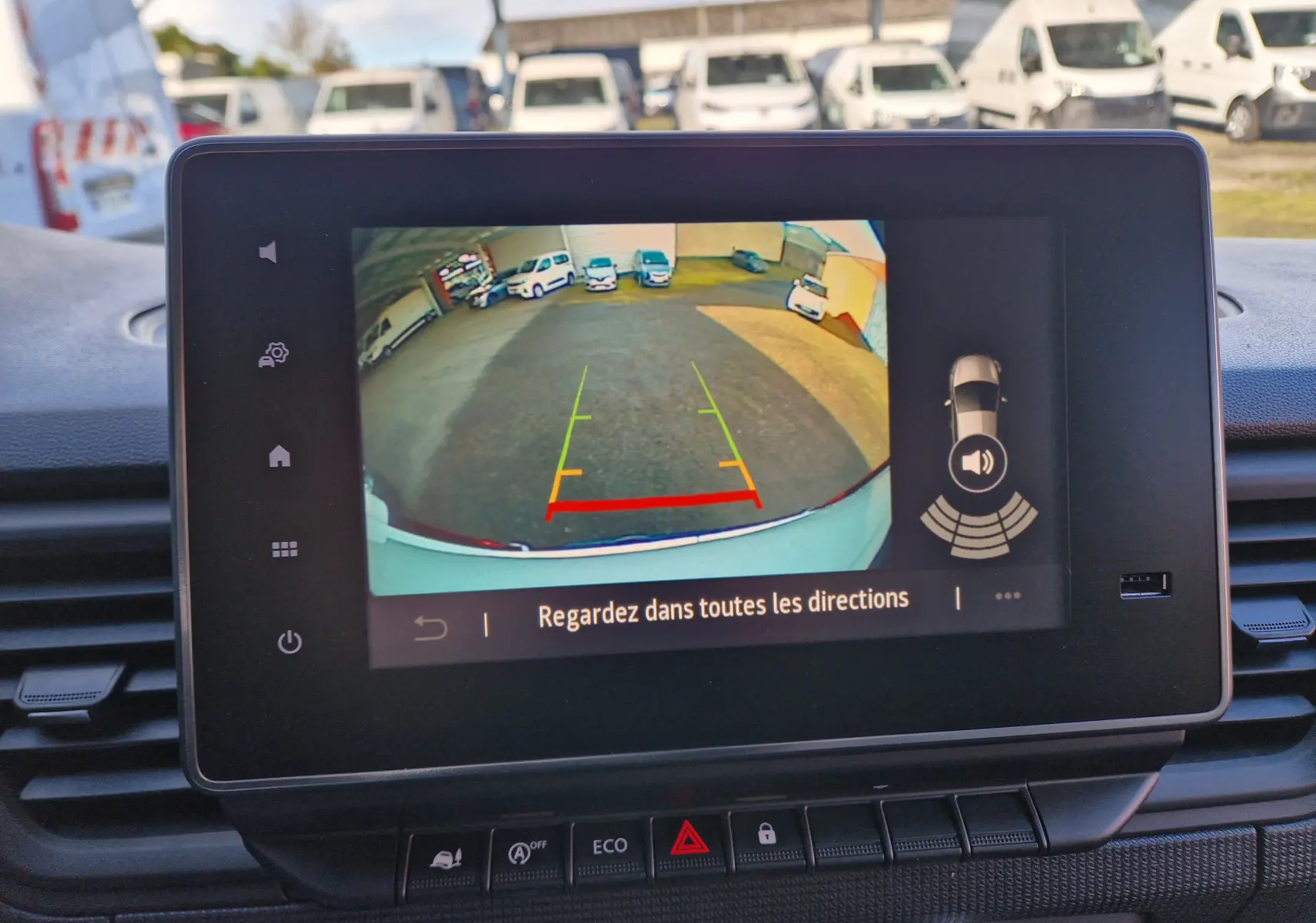 Écran tactile intérieur montrant la caméra de recul du Renault Trafic blanc, vue arrière avec guidage coloré.