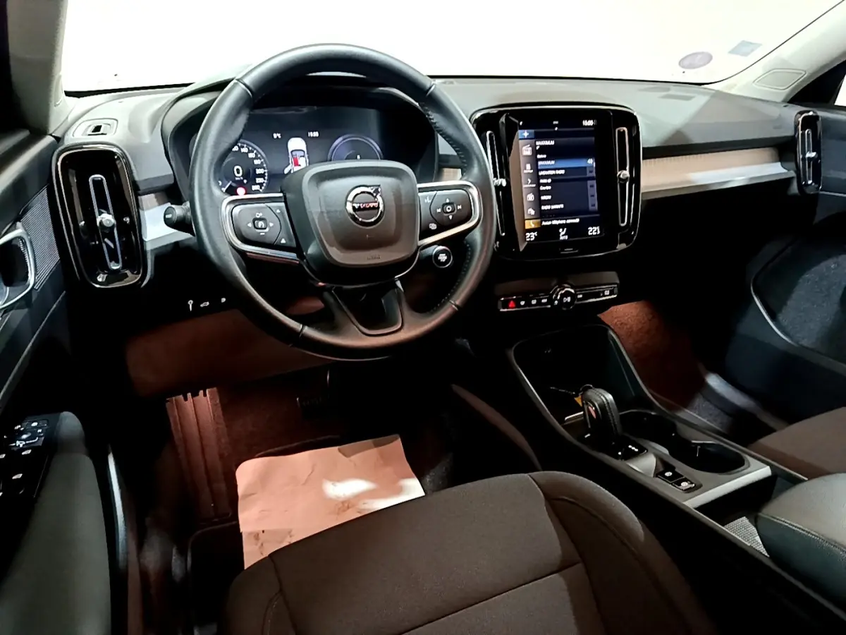 Intérieur noir du Volvo XC40 Recharge T4 2020, vue du poste de conduite avec volant multifonction et écran tactile central.