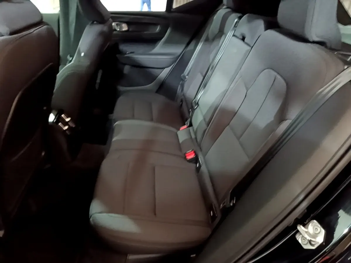 Vue intérieure côté droit des sièges arrière noirs du Volvo XC40 Recharge T4 Business 2020 avec ceintures visibles.