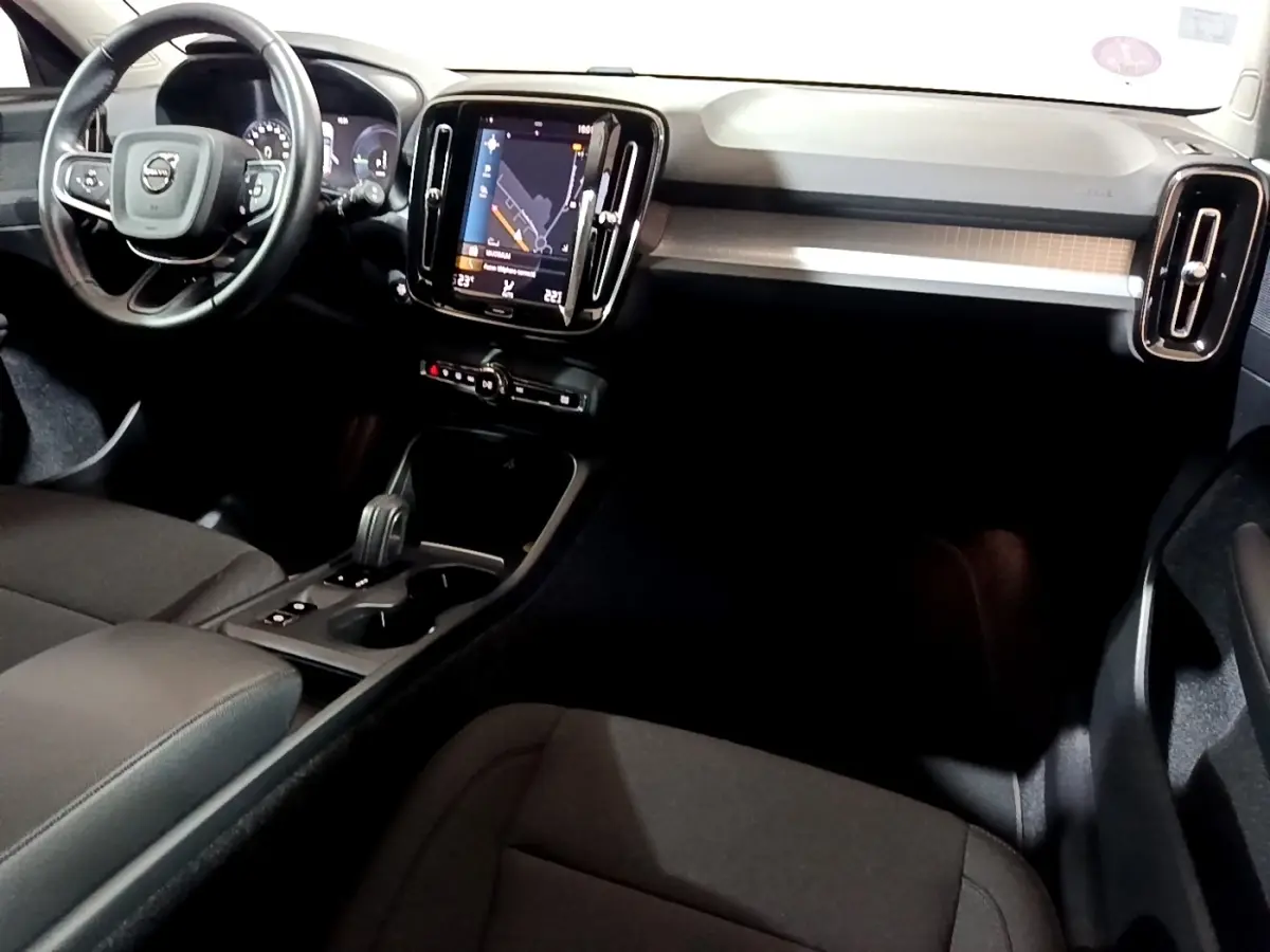 Intérieur noir du Volvo XC40 Recharge T4 vu côté conducteur, avec écran tactile central et volant multifonctions.