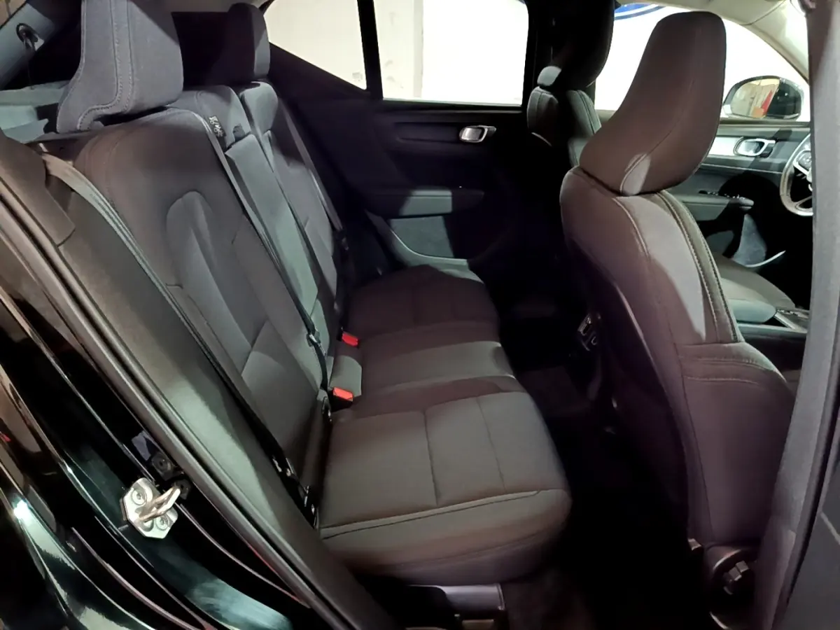 Vue intérieure côté gauche des sièges arrière noirs du Volvo XC40 Recharge T4 Business 2020 avec détails des appuie-têtes et ceintures.