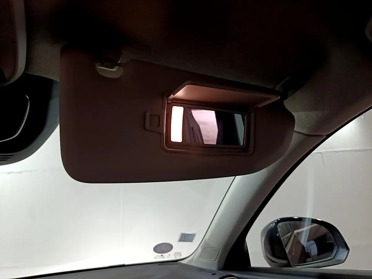Miroir de courtoisie éclairé sur pare-soleil côté conducteur dans l'habitacle d'un Volvo XC40 noir.