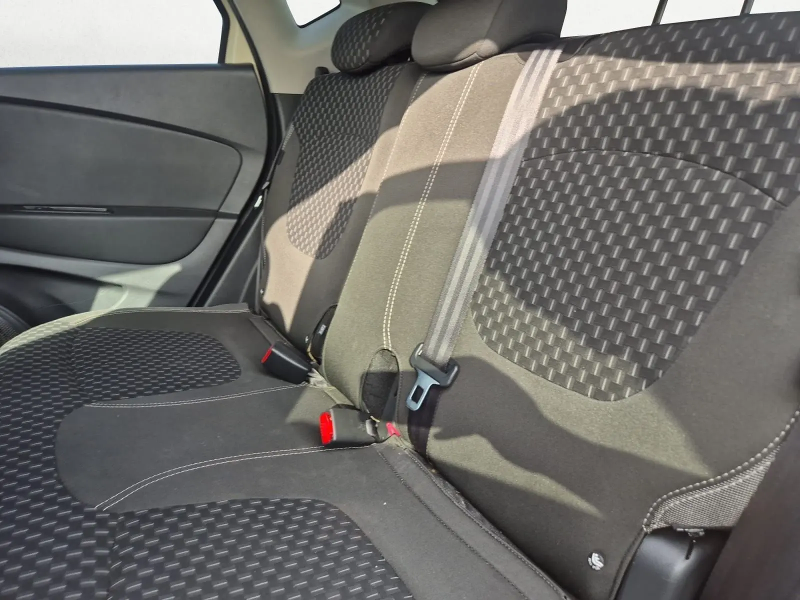 Vue intérieure côté droit des sièges arrière en tissu noir à motifs géométriques dans un Renault Captur beige/marron 2018.