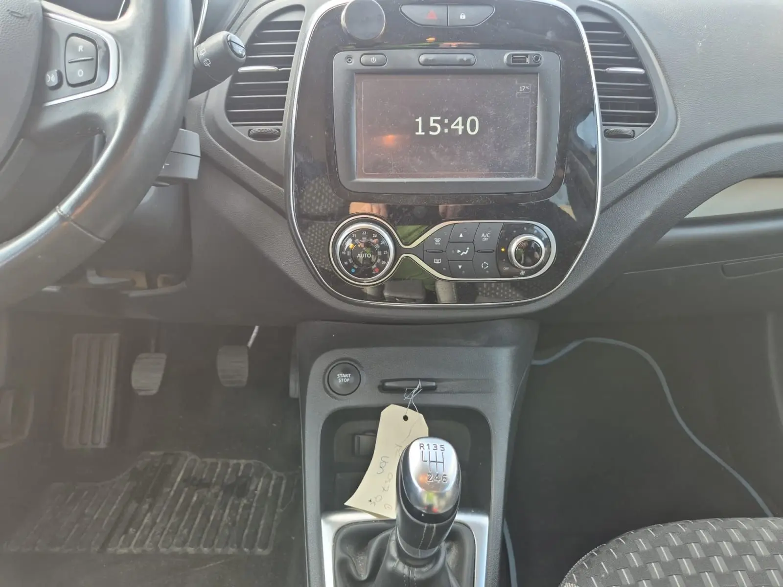 Vue intérieure centrée sur la console centrale d'une Renault Captur beige/marron 2018 avec levier de vitesse manuel et écran tactile.
