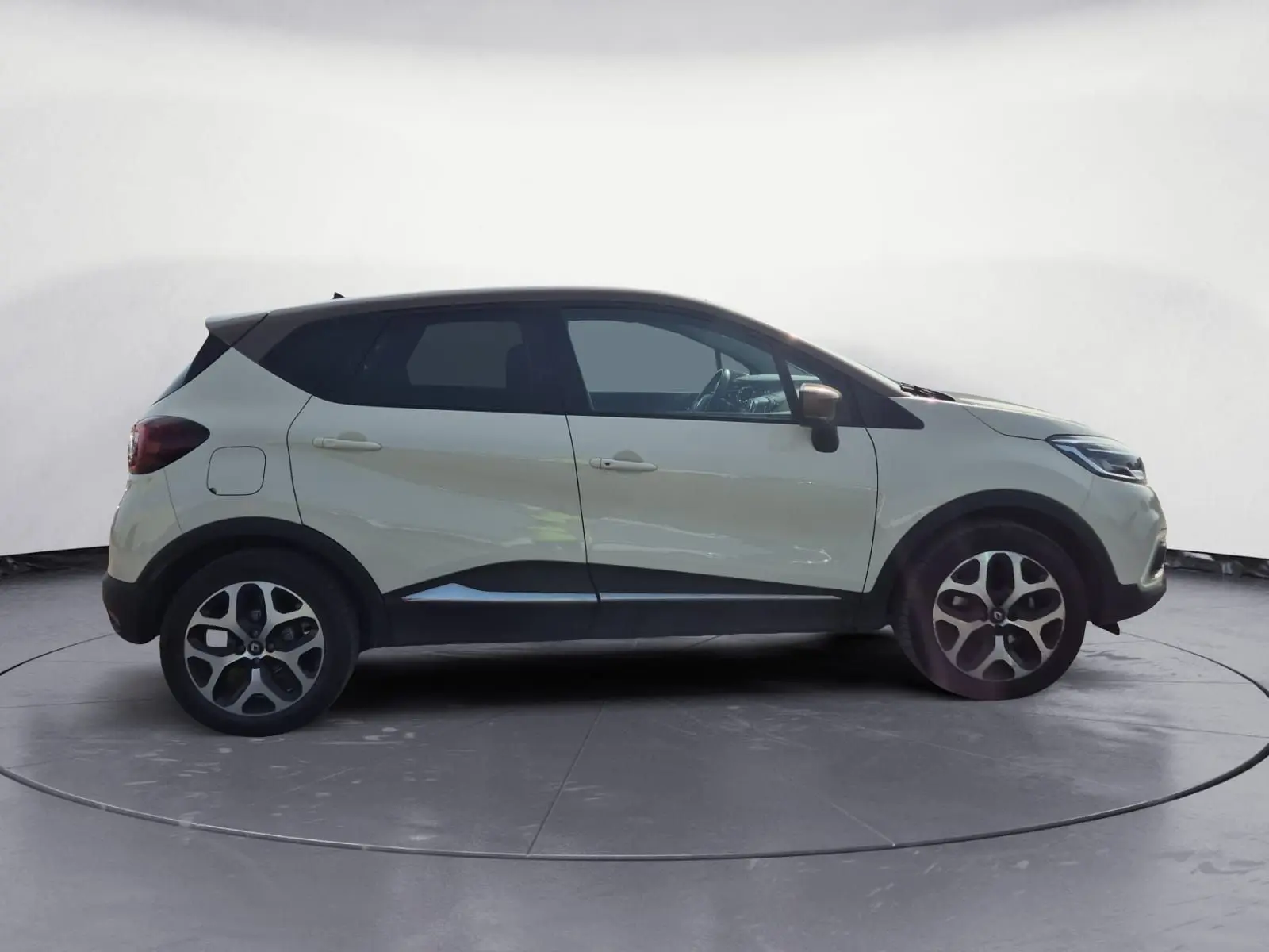 Renault Captur beige/marron vue de profil côté gauche, avec jantes alliage et toit noir contrasté.