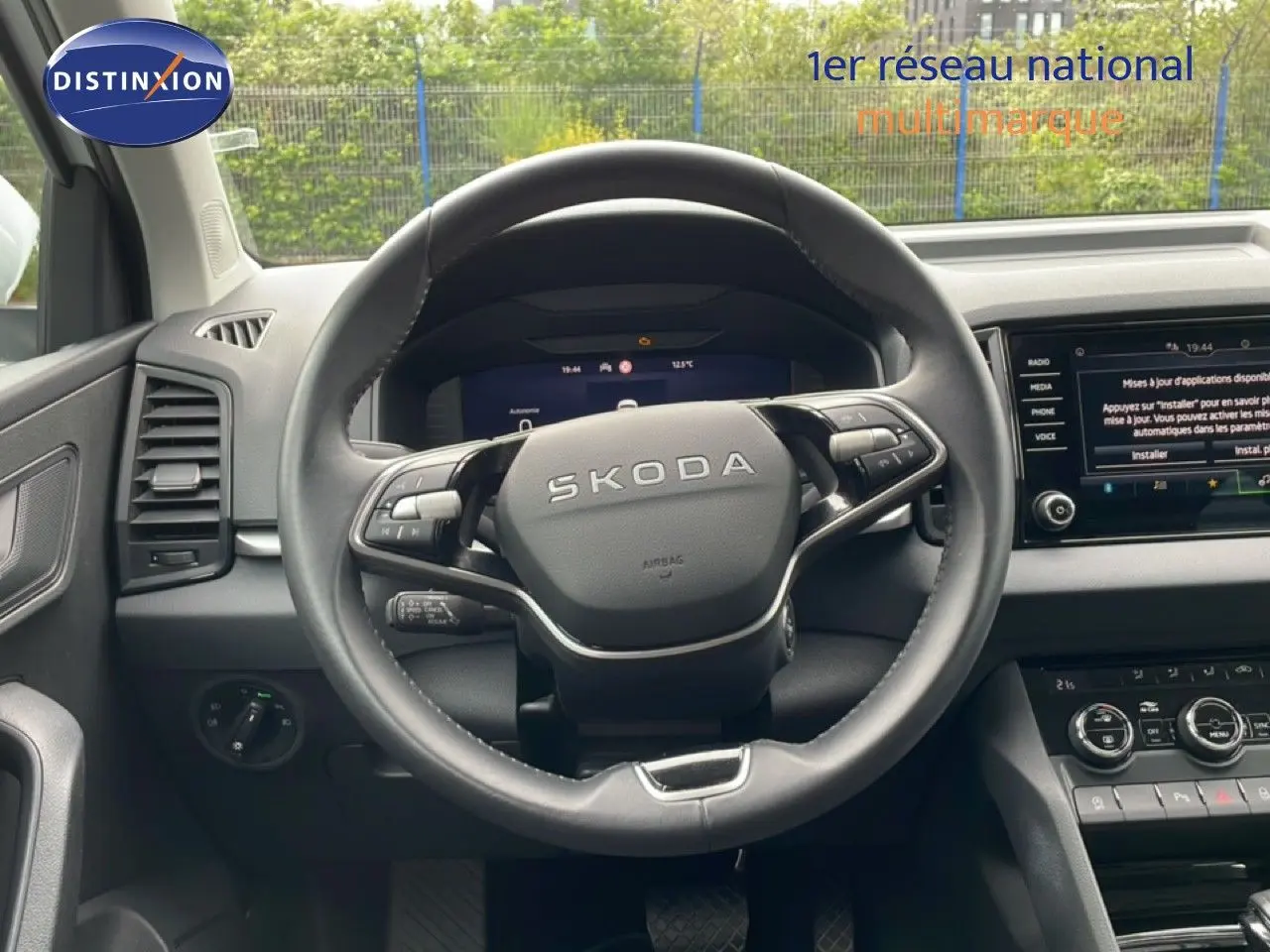 Vue intérieure centrée sur le volant noir SKODA du Karoq 2025, avec tableau de bord numérique et écran tactile visible.