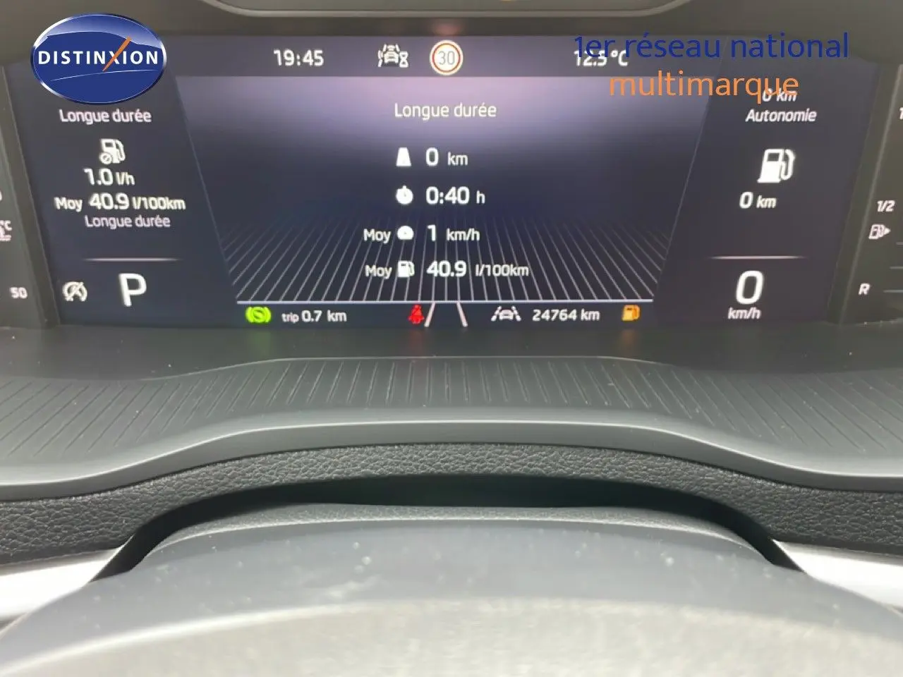 Tableau de bord numérique du Skoda Karoq 2025 affichant consommation, vitesse et autonomie, vue frontale rapprochée.
