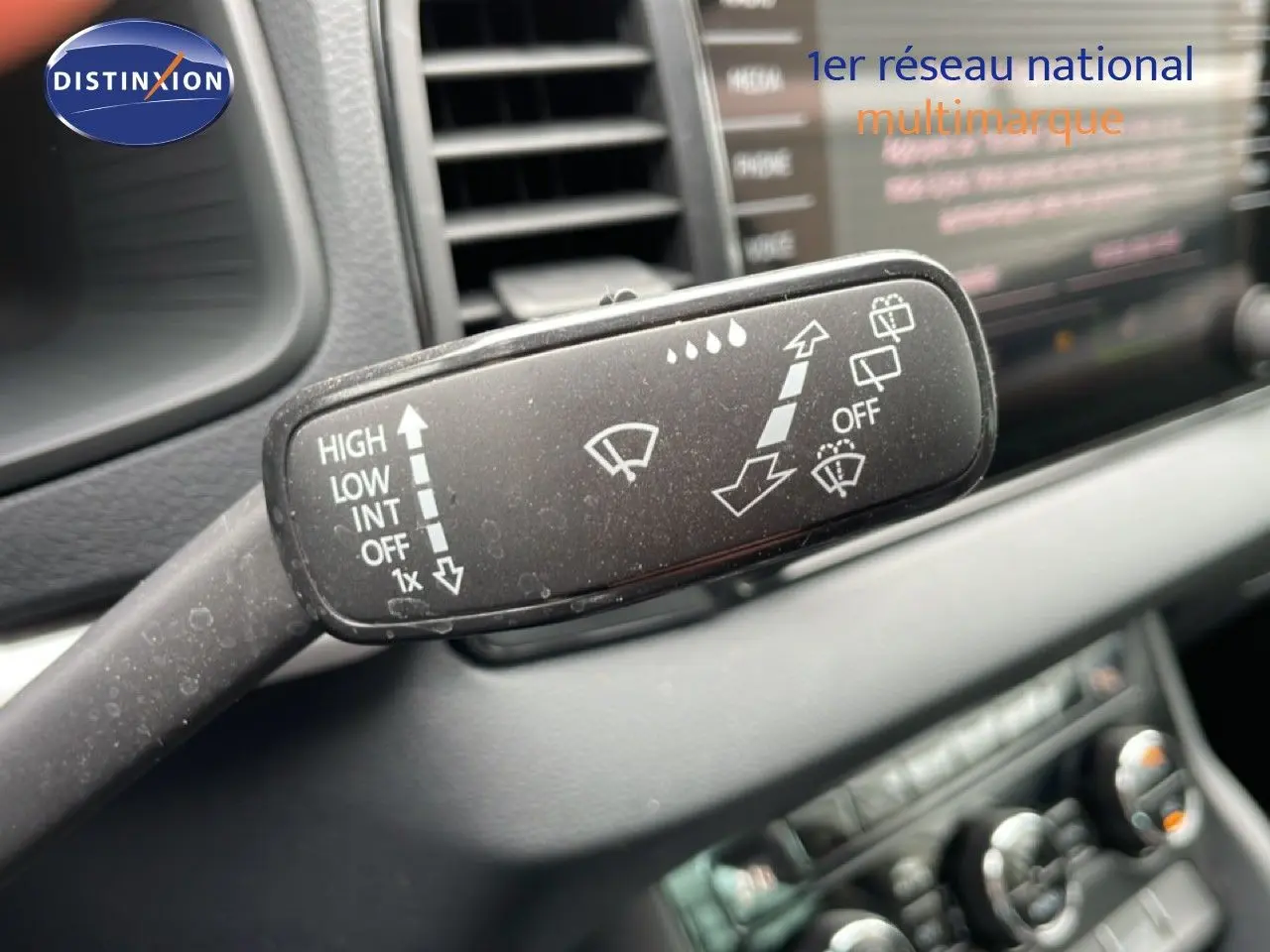 Gros plan sur la commande d’essuie-glace noire à gauche du volant dans l’habitacle du Skoda Karoq blanc glacier 2025.