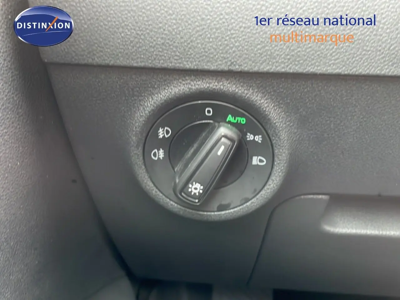 Gros plan sur la molette de réglage des phares du Skoda Karoq blanc glacier, intérieur noir.