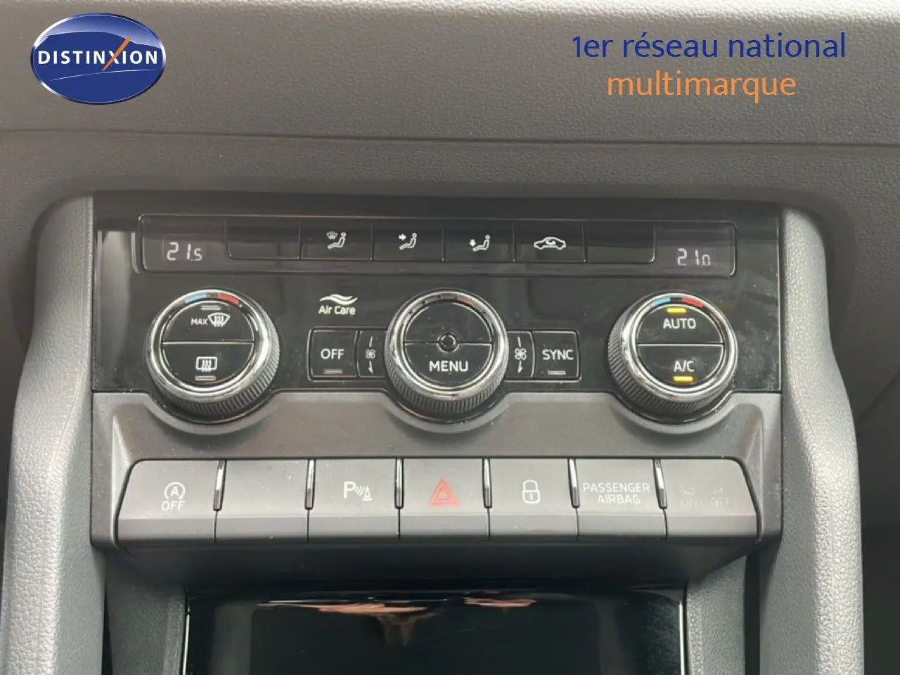 Gros plan sur la console centrale du Skoda Karoq blanc glacier, mettant en valeur les commandes de climatisation et les boutons de fonction.