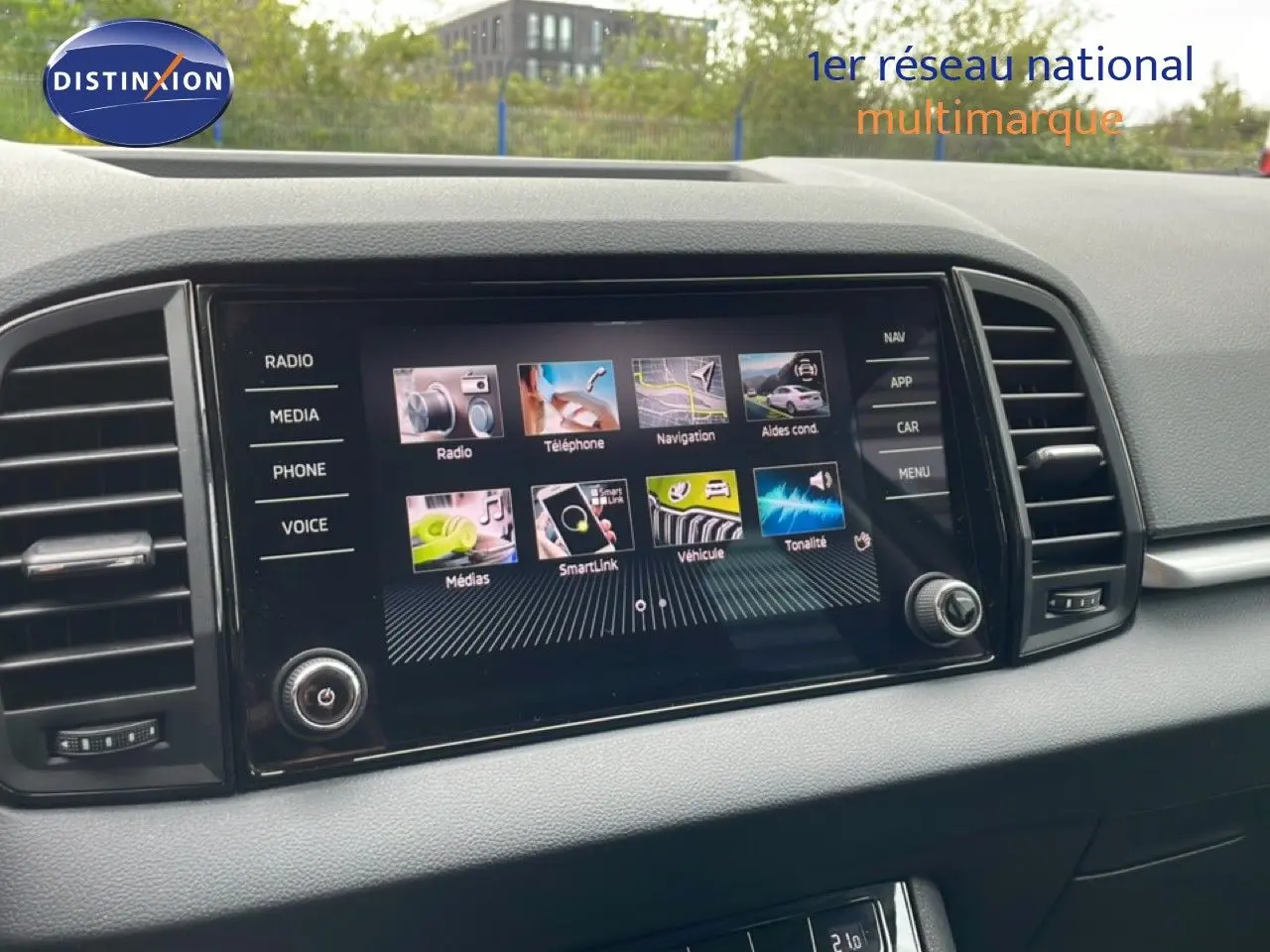 Écran tactile central du tableau de bord du Skoda Karoq blanc glacier, avec interface multimédia affichée.