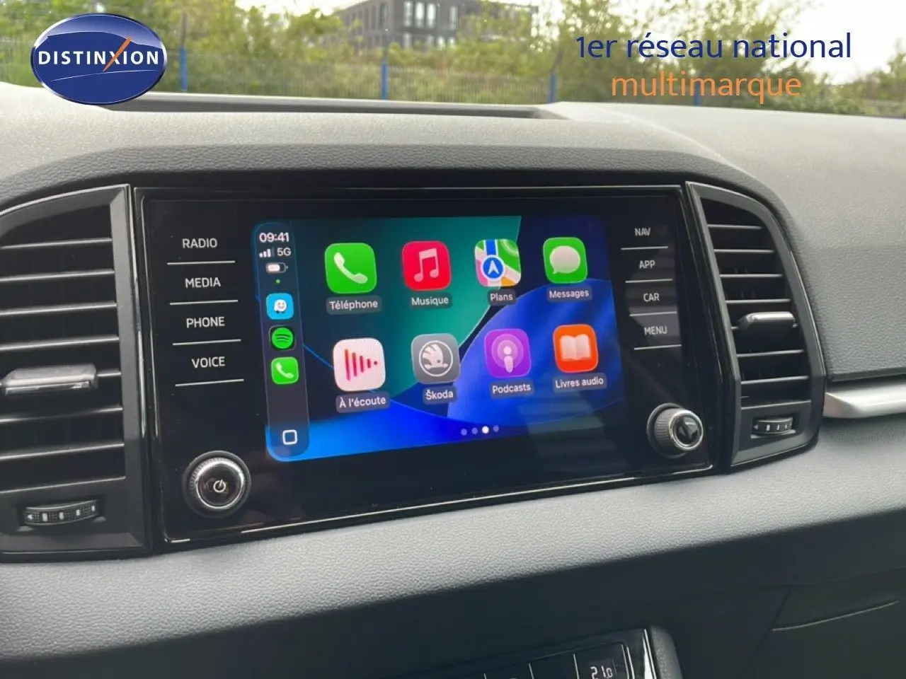 Écran tactile central du tableau de bord du Skoda Karoq blanc glacier, affichant Apple CarPlay.