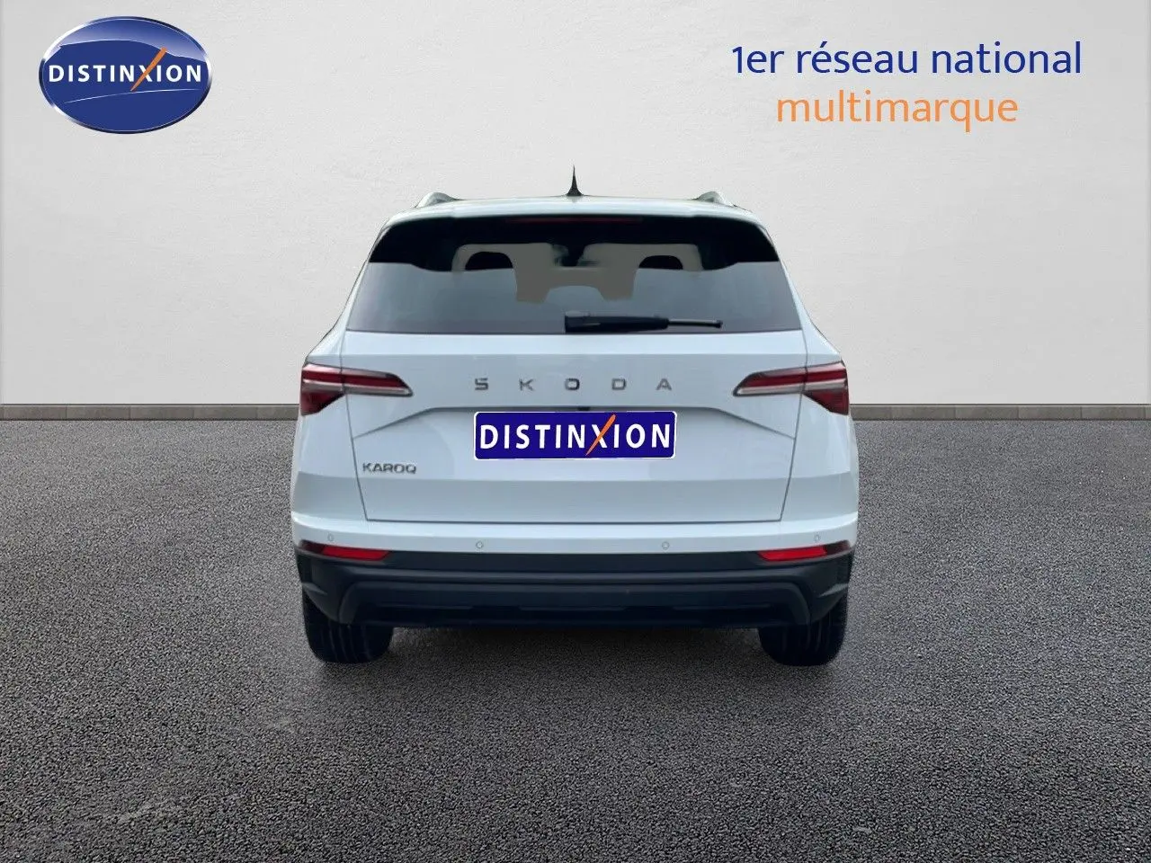 Vue arrière d'un Skoda Karoq blanc glacier 2025 avec feux arrière LED et logo SKODA visible.