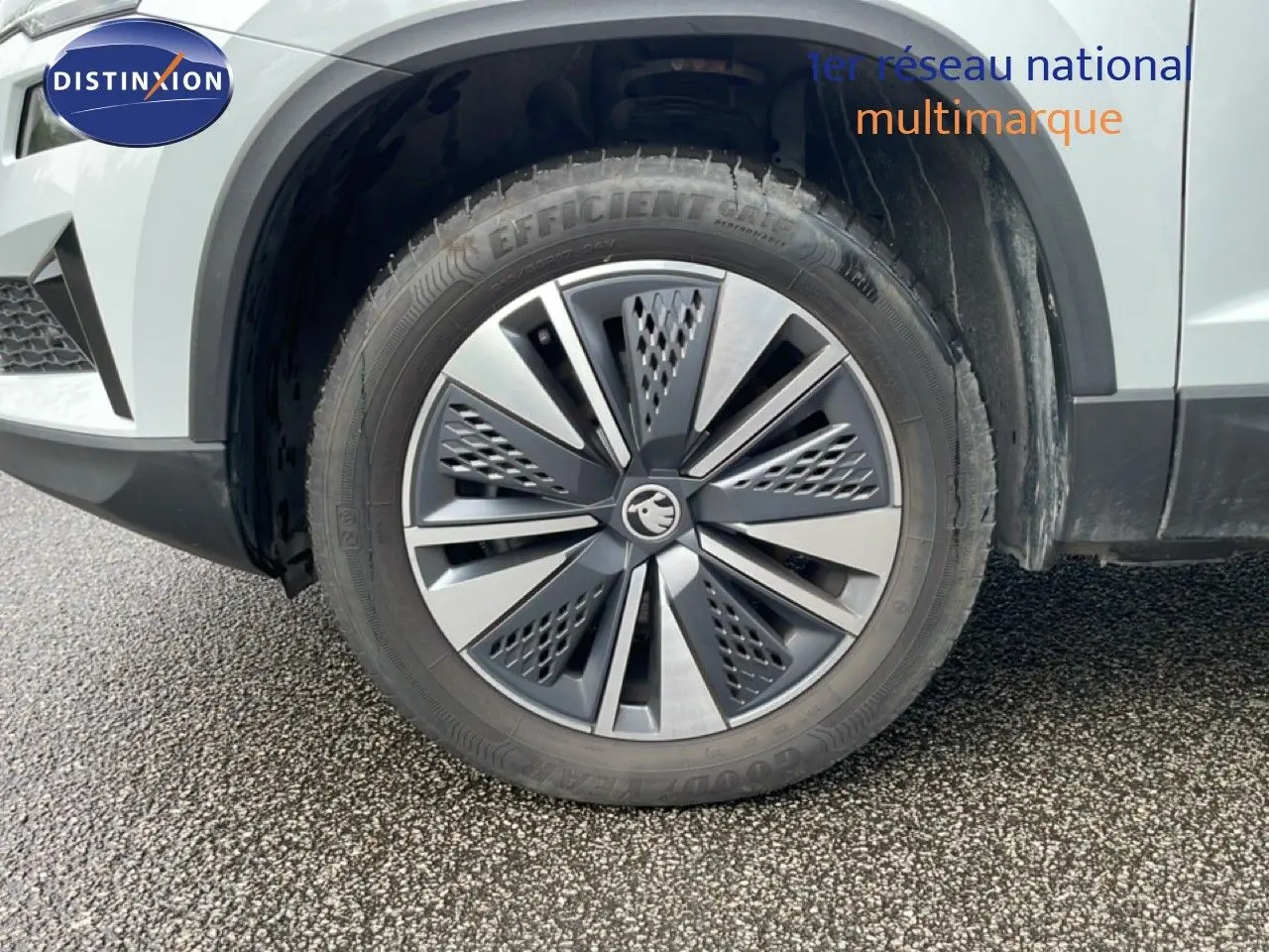 Gros plan sur la roue avant droite d’un Skoda Karoq blanc glacier avec jante alliage moderne.