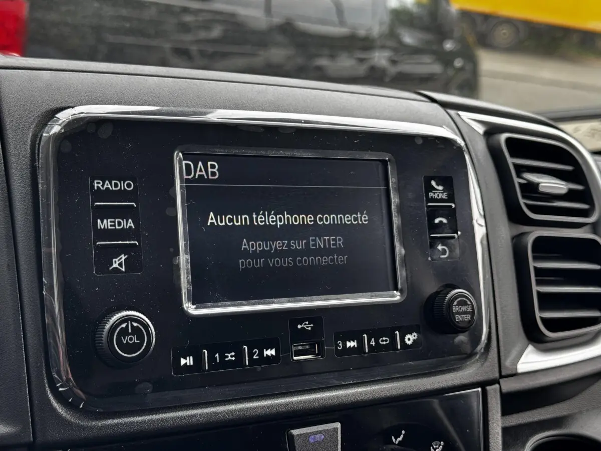 Gros plan sur l’écran tactile central du tableau de bord du Peugeot Boxer Fourgon blanc, affichant un message de connexion téléphone.