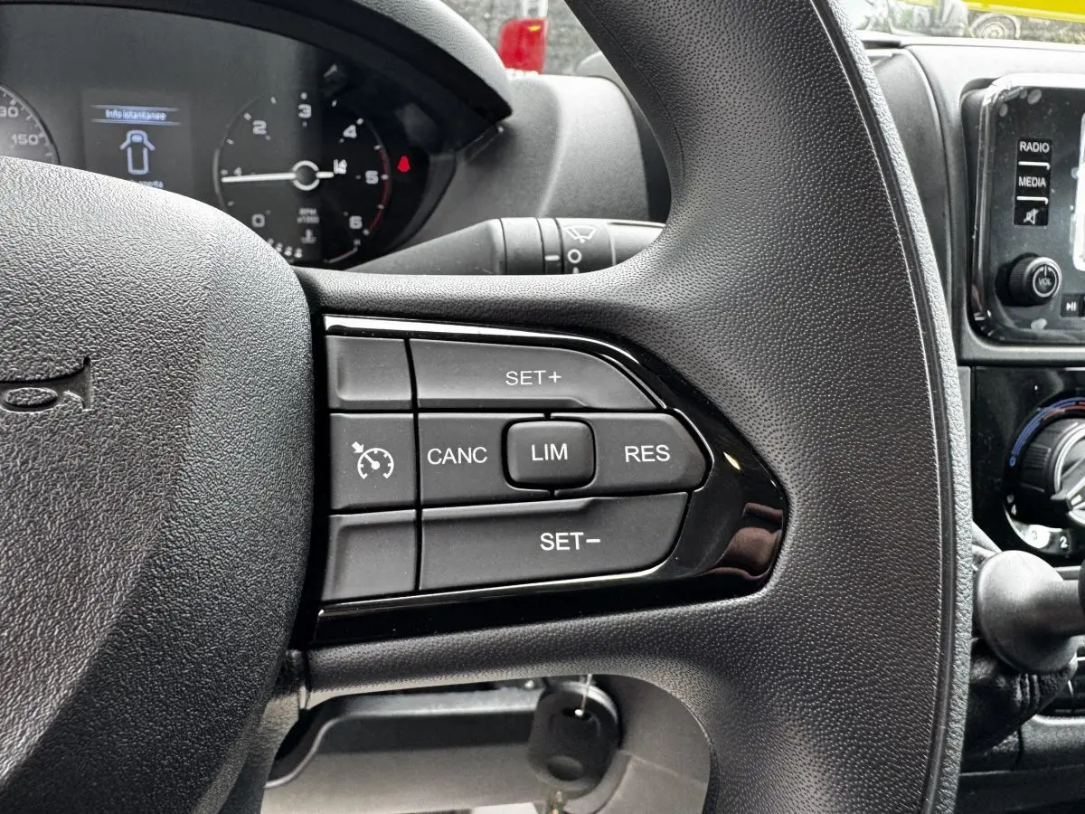 Gros plan sur le volant noir du Peugeot Boxer Fourgon 2026, montrant les commandes du régulateur de vitesse.