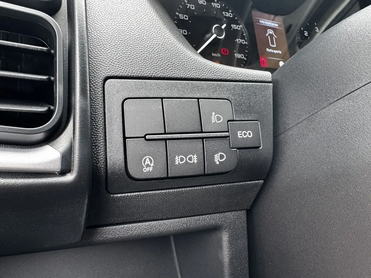 Gros plan sur les commandes d’éclairage et mode ECO du tableau de bord noir du Peugeot Boxer Fourgon blanc.