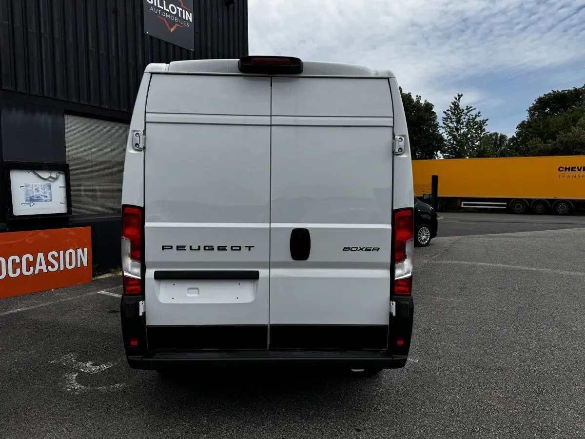 Vue arrière d'un Peugeot Boxer Fourgon blanc, portes battantes fermées, sur parking extérieur.