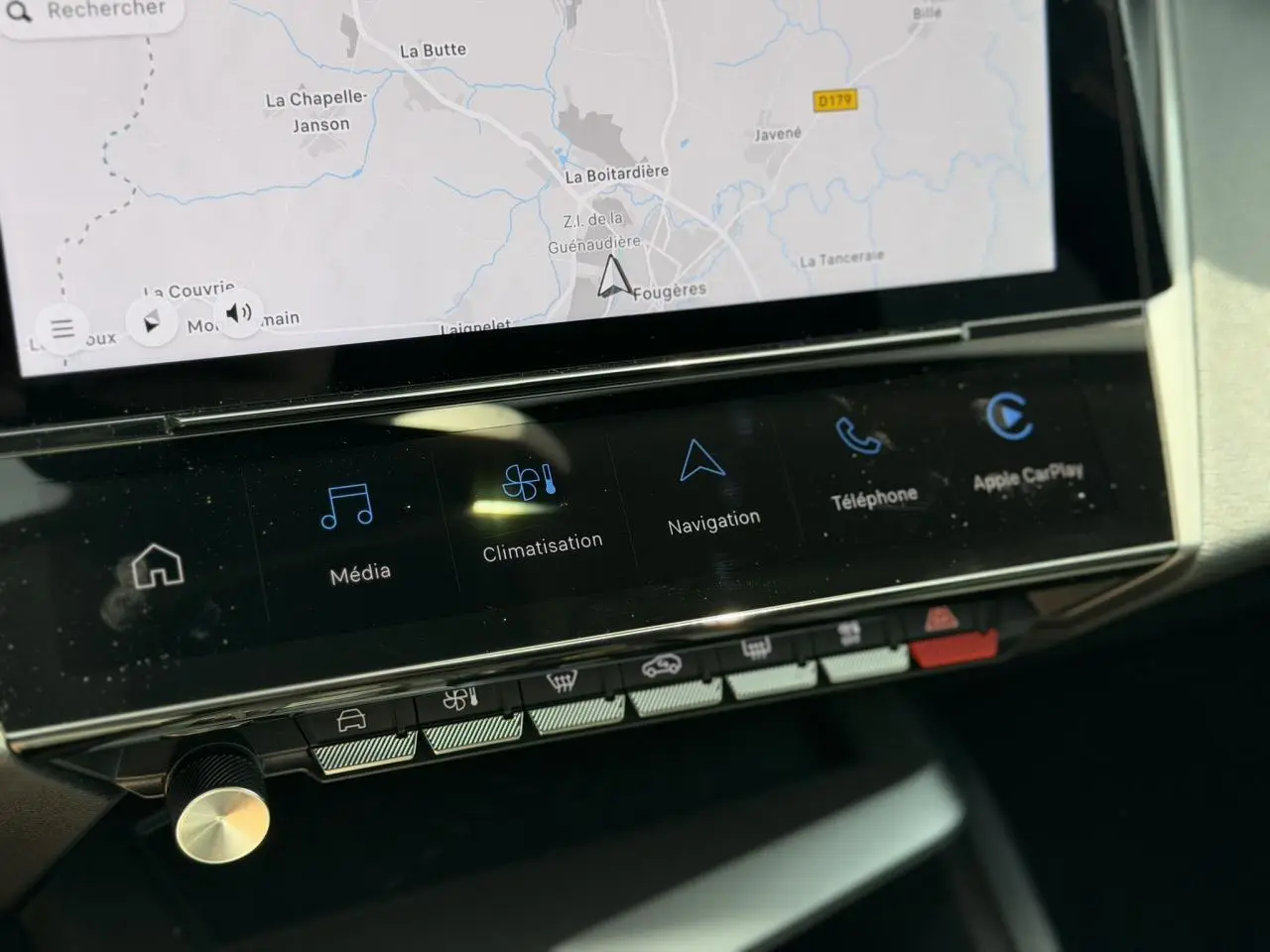 Gros plan sur l’écran tactile central 10'' de la Peugeot 308 Hybrid 2025 avec navigation et commandes climatisation.