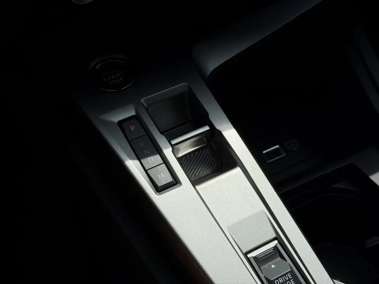 Gros plan sur la console centrale argentée avec sélecteur de boîte auto et bouton start du Peugeot 308 Hybrid 2025.