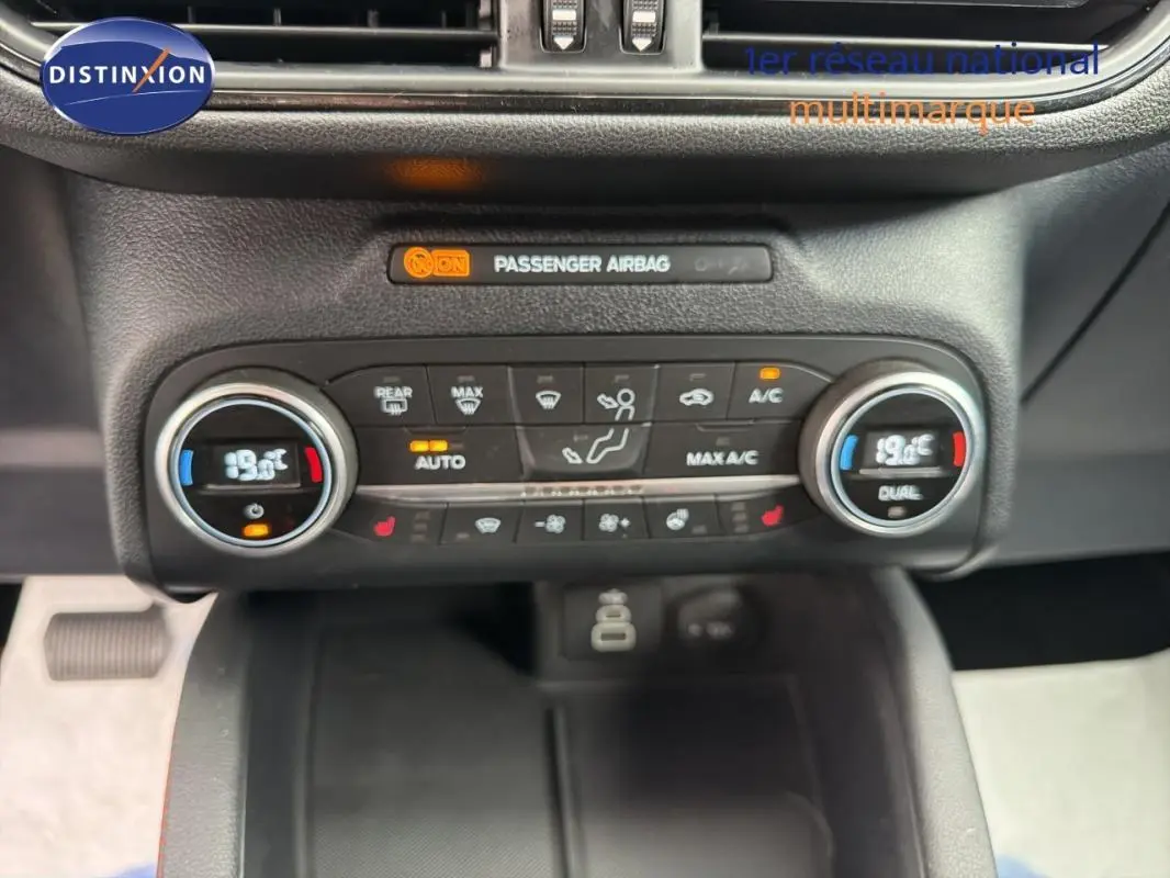 Vue rapprochée de la console centrale du Ford Kuga gris foncé 2022, montrant les commandes de climatisation et l'affichage digital.