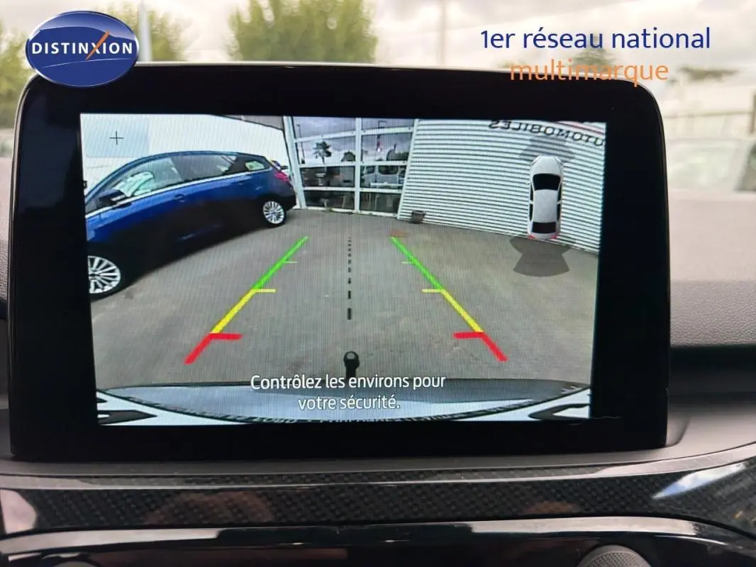 Écran tactile intérieur montrant la caméra de recul du Ford Kuga gris foncé avec lignes de guidage colorées.