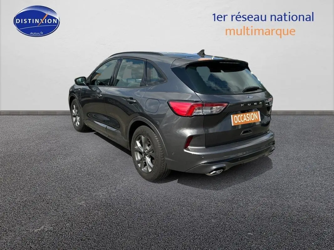 Vue 3/4 arrière droite d’un Ford Kuga gris foncé 2022 avec jantes alliage 18 pouces et attelage fixe visible.