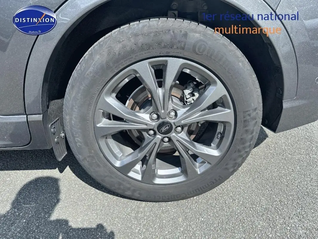 Gros plan sur la jante alliage 18 pouces gris foncé du Ford Kuga 2.5 Hybride, avec pneu Continental visible.