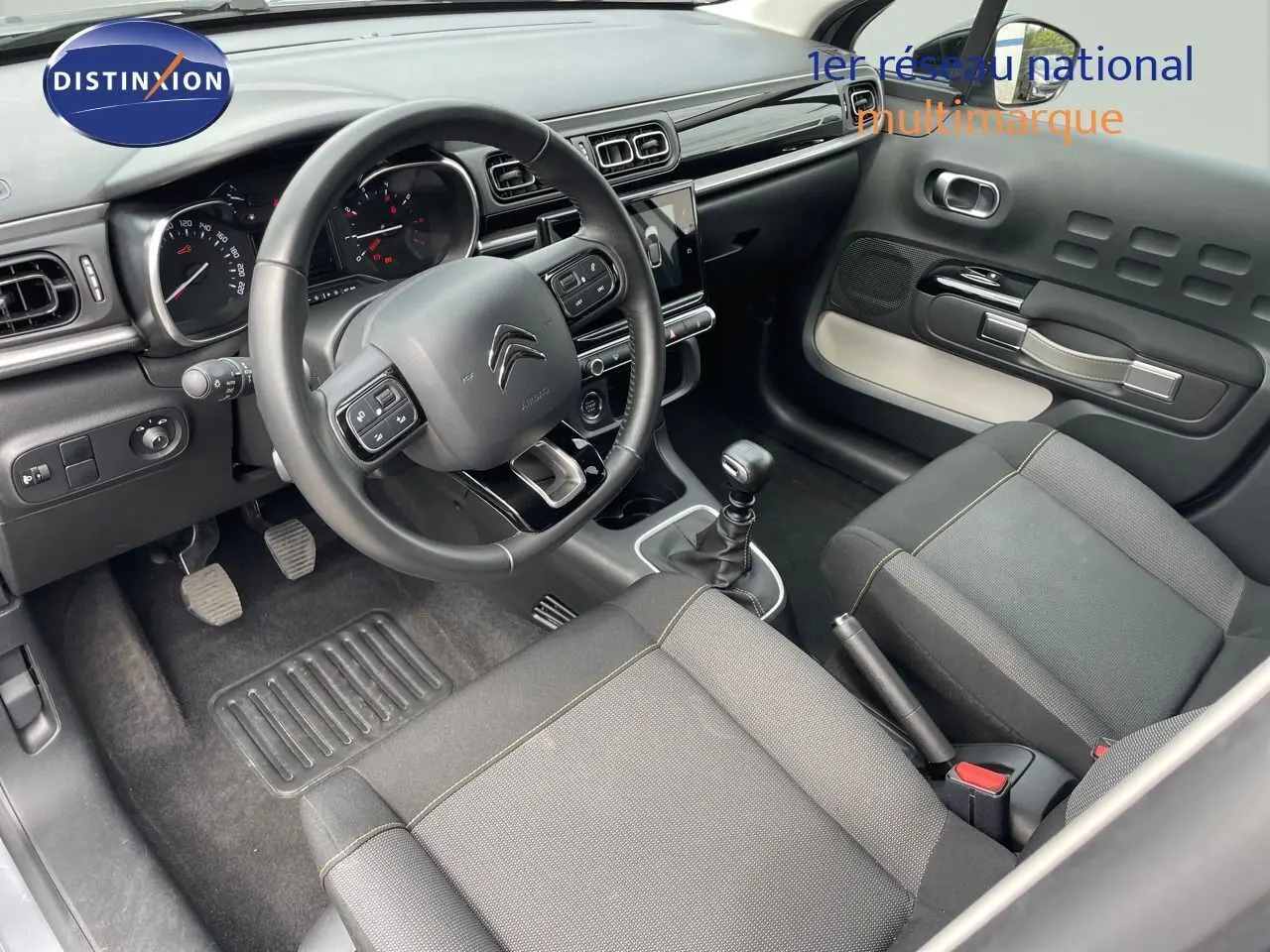 Intérieur de la Citroën C3 2021 en gris, vue côté conducteur montrant le tableau de bord et la boîte manuelle.