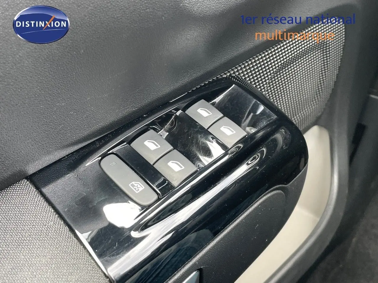 Gros plan sur les commandes des vitres électriques côté conducteur d'une Citroën C3 gris Artense métal de 2021.