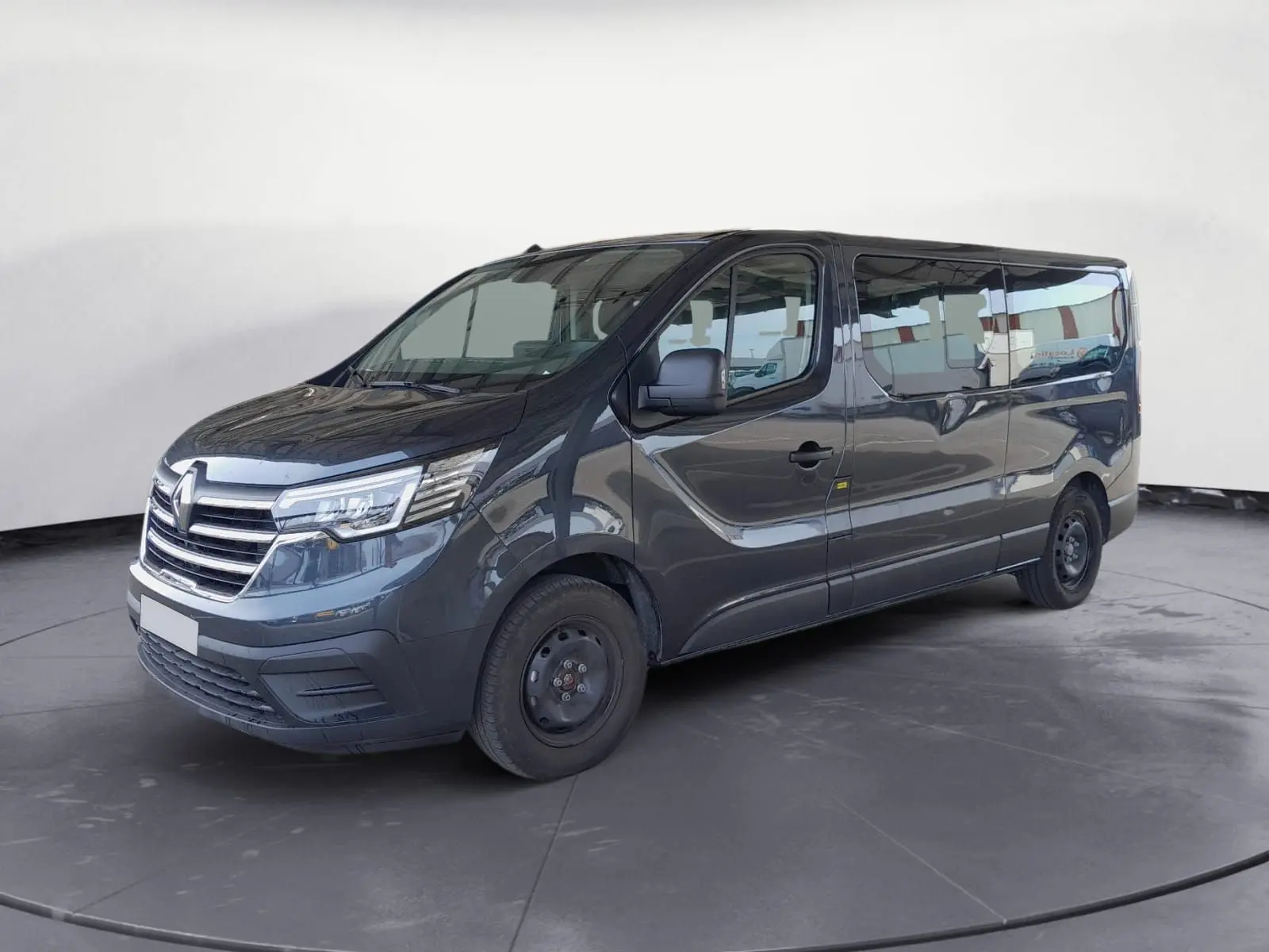 Renault Trafic Combi gris foncé métal vu en 3/4 avant droit, avec grandes fenêtres latérales et jantes acier noires.