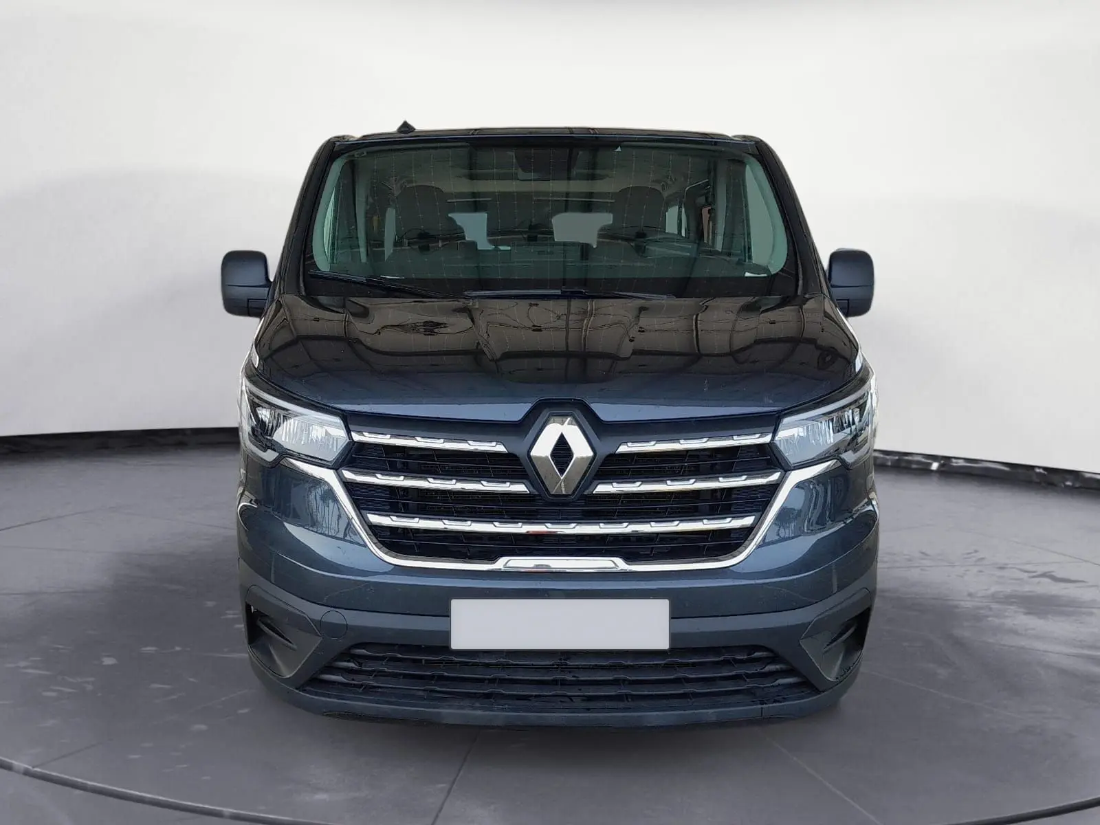 Vue frontale d'un Renault Trafic Combi gris foncé métal, mettant en valeur sa calandre chromée et son logo central.