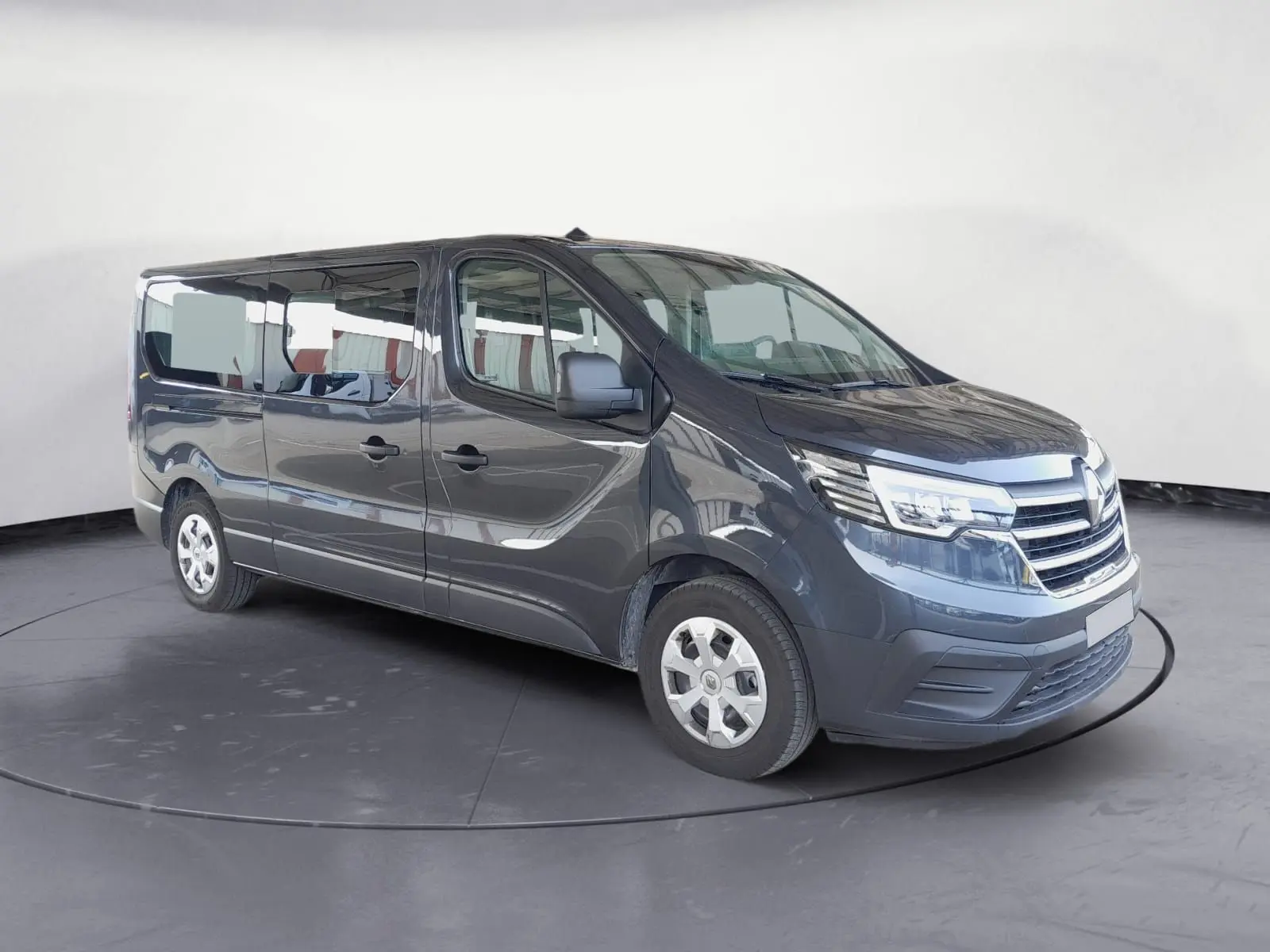 Renault Trafic Combi gris foncé métal vu en 3/4 avant droit, mettant en valeur ses grandes vitres latérales et sa calandre chromée.